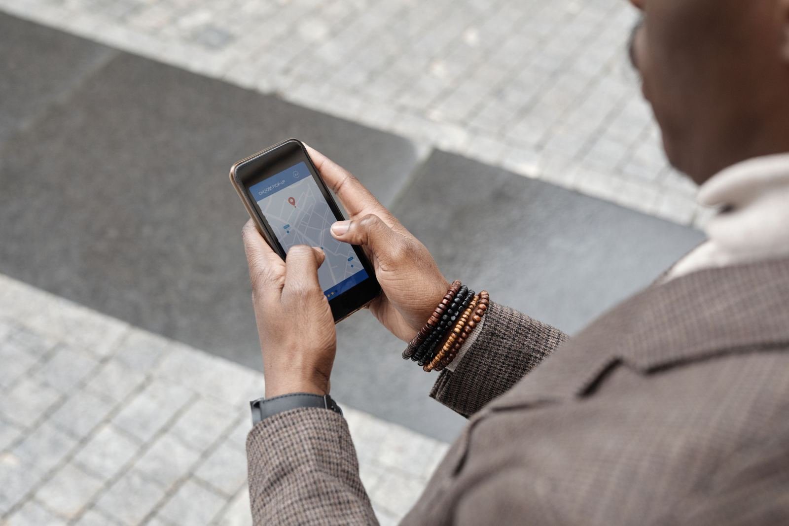 Someone stands outside and uses a phone map app.