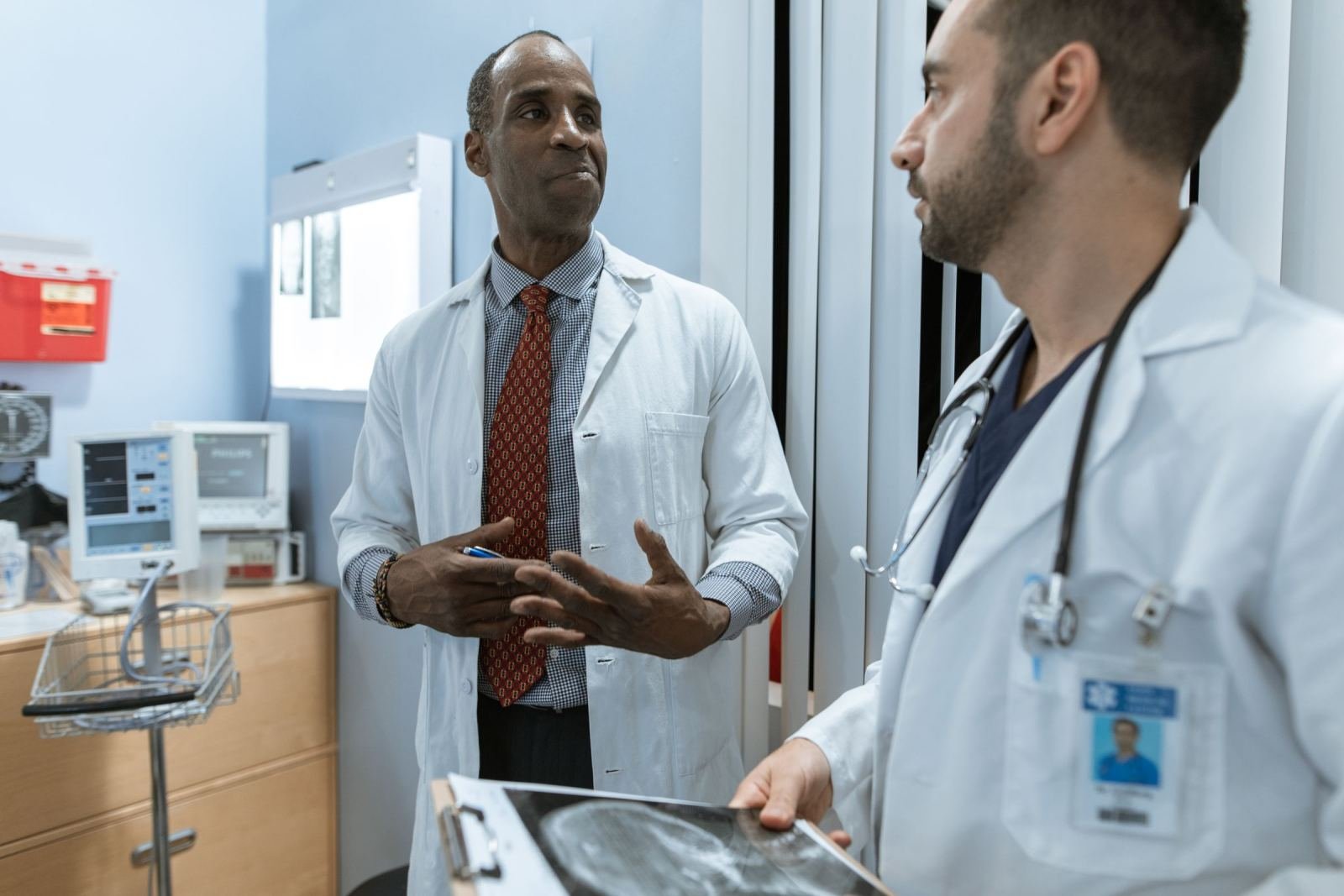 Two physicians in white coats look at a patient's X-ray in a clinic