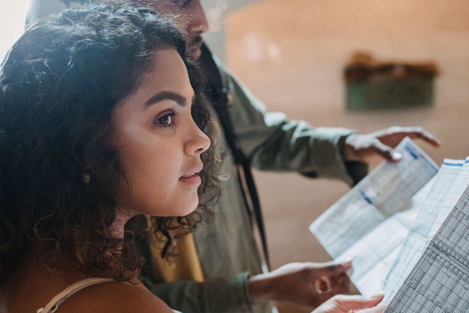 A man and a woman look over a printed paper side by side.